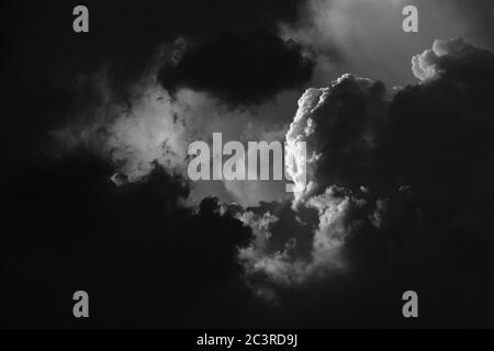 Black and white cloudscape - pitch black thunder clouds part to reveal sun dappled white clouds behind, Ottawa, Ontario, Canada. Stock Photo