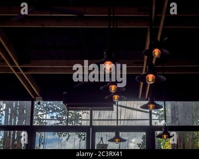 Lighting decoration, vintage ceiling lights hanging from ceiling in cafe, industrial style light bulbs interior design. Stock Photo