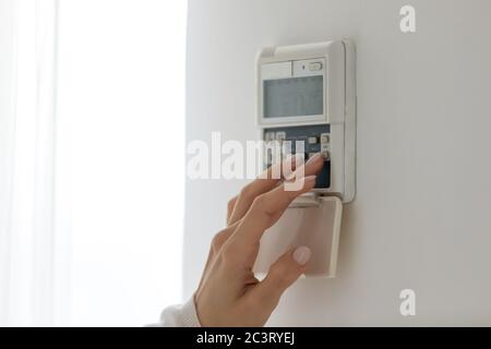 Female fingers set comfortable temperature at home use digital thermostat Stock Photo
