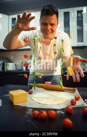 man making pizza ingredients like salami mushrooms olive cheese freeze in air Stock Photo