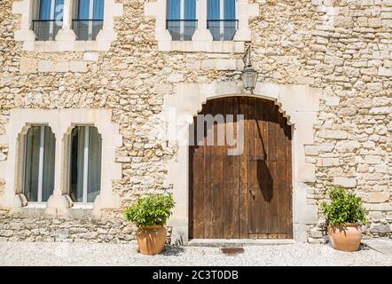 Old country chateau, house with stone wall, wooden door and windows. Historic building exterior Stock Photo