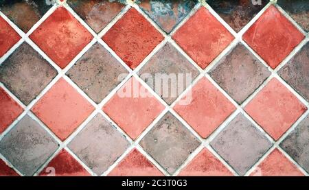 Old porcelain checkered tiles floor texture with tiles of red and gray colors and cement of white color Stock Photo