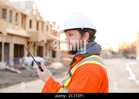 Portrait of engineer talking by walkie talkie on construction site. Stock Photo