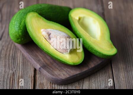 Avocado sliced half on wooden cutting board for avocado salad / Fruits healthy food concept Stock Photo