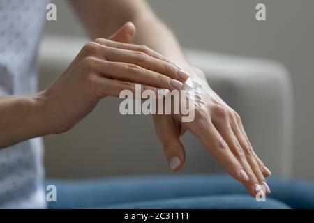 Close up view of woman applying cream on hand Stock Photo