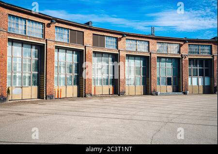 An old rail yard building with large doors made out of red bricks photographed on a sunny summer day. Stock Photo