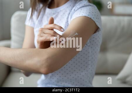 Woman applying cream on arm using natural treatment closeup view Stock Photo