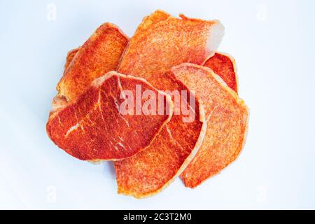 Dried slices of pork, beef with spices on a white background. Crispy meat chips. Tasty appetizer. View from above Stock Photo