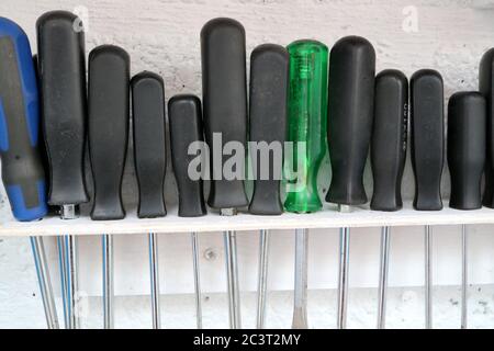row of screwdrivers on home made rack in a workshop Stock Photo