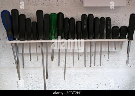 row of screwdrivers on home made rack in a workshop Stock Photo
