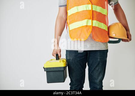 Cropped image of construction worker with toolbox and hardhat in his hands ready for work Stock Photo