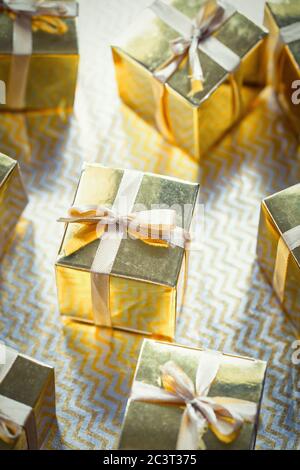 Group of gold sparkling gift boxes, beautiful gold packaging surprise with bow on sparkling background Stock Photo