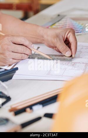 Hands of architect using pencil and ruler when drawing blueprint of house Stock Photo
