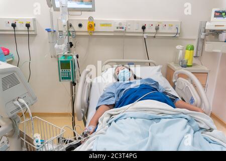 Kota Kinabalu, Sabah, Malaysia-May 30, 2020 : Young Asian Chinese lady in Contraction pain on hospital labour room ward bed waiting to delivery newbor Stock Photo