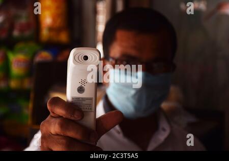 Indian shopkeeper showing a thermal gun scanner or digital thermometer Stock Photo