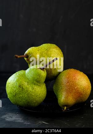 selective focus: large ripe pears with water drops on a dark background Stock Photo