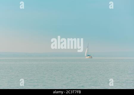 Sailing. Ship yachts with sails in the open misty sea. Stock Photo