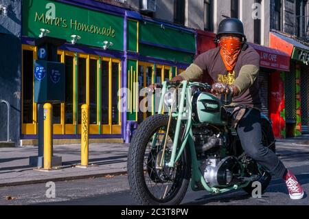 Man riding a Triumph motorcycle motorbike in East Village, alphabet city Emergency staris fire scape. New York. Alphabet City Apartments.  House with Stock Photo