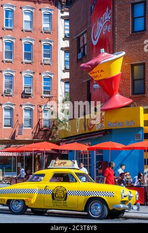 1950 Studebaker yellow taxi outside the Caliente Cab Mexican restaurant on Seventh Avenue, Greenwich Village, New York City, USA. Stock Photo