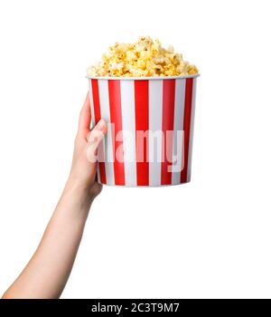 Woman hand holding striped bucket with popcorn isolated on white background Stock Photo