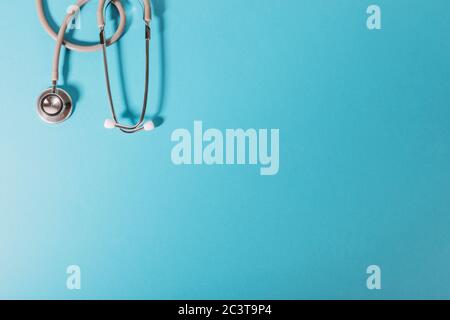 Medical Concept. Top view of stethoscope, clipboard, pen and eye glasses on blue background. Flat lay and copy space. Stock Photo