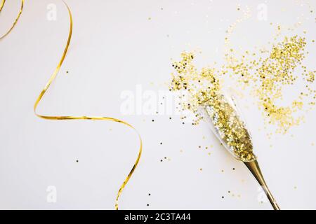 Champagne glasses with confetti. Flat lay, top view celebrate party concept. New Year Gold Composition Stock Photo