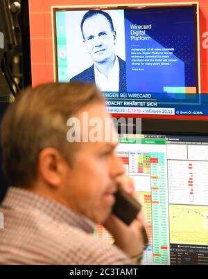 22 June 2020, Hessen, Frankfurt/Main: On the television monitor of a stockbroker on the trading floor of the Frankfurt Stock Exchange, the news about the suspected fraud at Wirecard runs with a photo and a quotation of the resigned former CEO Markus Braun. The accounting scandal surrounding the payment service provider Wirecard dragged its shares even deeper into the downward spiral on Monday. In early trading, they lost a further almost 38 percent to 15.10 euros, having already slumped by up to 82 percent on Thursday and Friday. The stock market value thus shrank to almost 1.9 billion euros, Stock Photo