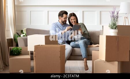 Excited young couple having fun with tablet on moving day Stock Photo