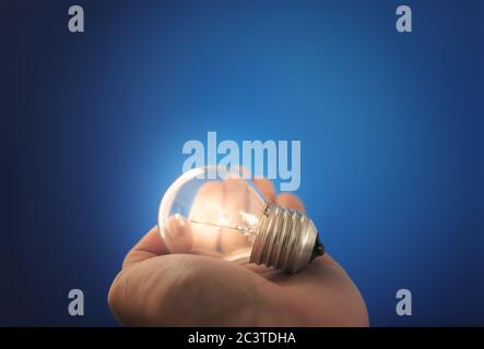 New ideas, innovation and inspiration concept. Glowing light bulb on hand Stock Photo