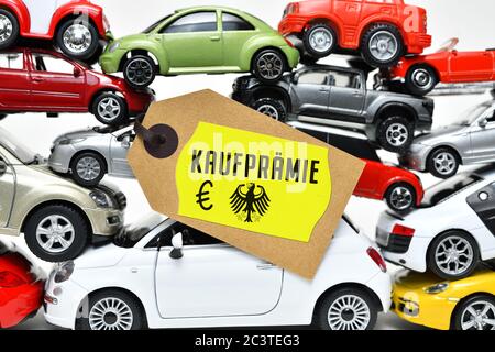 PHOTOMONTAGE, stacked toy cars with label and the label purchase premium, FOTOMONTAGE, Gestapelte Spielzeugautos mit Etikett und der Aufschrift Kaufpr Stock Photo