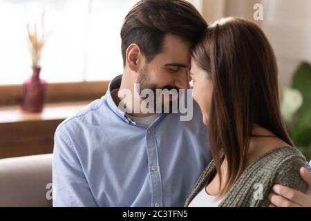 Close up young loving couple touching foreheads, enjoying tender moment Stock Photo