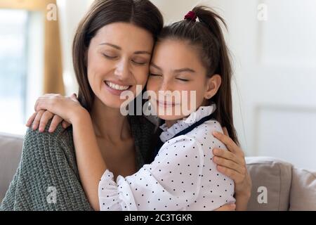 Close up smiling mother and little daughter enjoying tender moment Stock Photo