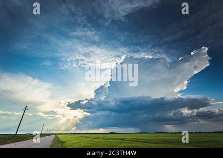 Cumulonimbus storm clouds in evening light with sun rays Stock Photo