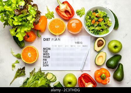 Diet Plan and healthy food products, salad, fresh vegetables, juice on the white table. Top view Stock Photo