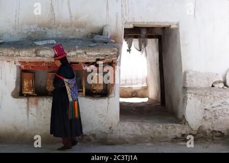 Alchi, India - June 24: Ladakhi woman in the traditional hat before the monastery in Alchi is praying, the Indus valley on June 24, 2017 Stock Photo