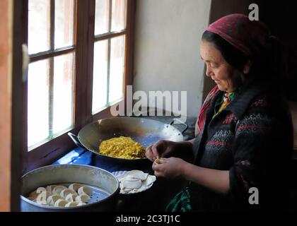 Nubra Valley, India - July 10: Ladakhi woman preparing traditional Momo dumplings by the window in one's kitchen, on July 10, 2017 Stock Photo