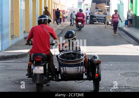 Santiago de Cuba, CUBA Couple riding in motorcycle with sidecar on the road ni Santiago de Cuba. Stock Photo