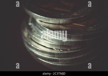 Coins stacked on each other in different positions on dark background. Money concept. Closeup. Money and saving concept. Success, wealth and poverty,