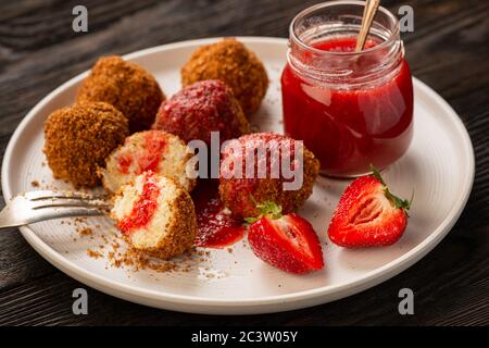 Homemade cottage cheese balls, hungarian sweet dessert served with strawberry mousse. Stock Photo