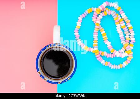 Cup of coffee on a pink and turquoise background and candy beads Stock Photo