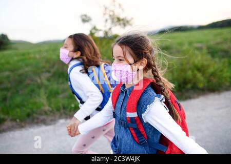 Two small girls on trip outdoors in nature, wearing face masks. Stock Photo