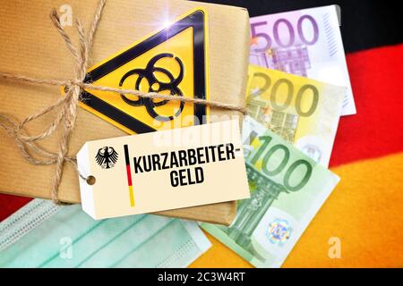 PHOTOMONTAGE, package Biogefährdungszeichen on Germany flag with tag and the label Kurzarbeitergeld, FOTOMONTAGE, Paket mit Biogefährdungszeichen auf Stock Photo
