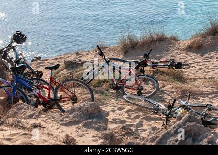 Group Of Cruiser Bikes Parked On The Beach In A Sand Dune At Sunset, Formentera Island, Mediterranean Sea, Spain Stock Photo