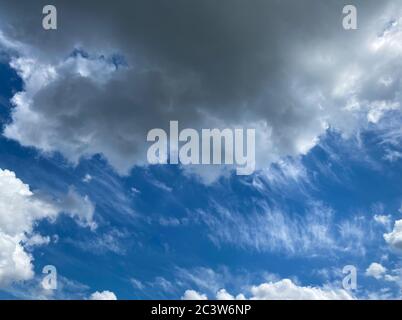 View into deep blue sky with stratocumulus and cirrus clouds on windy day announcing occasional summer rain showers Stock Photo