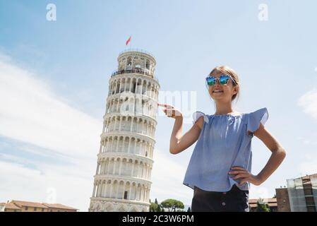 Happy child girl pointing Leaning Tower of Pisa