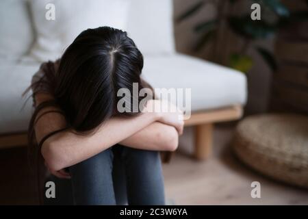 Sad teenager feeling bad alone holding head in hands, feeling depressed, regrets of mistake, having problems, adolescent girl with broken heart Stock Photo