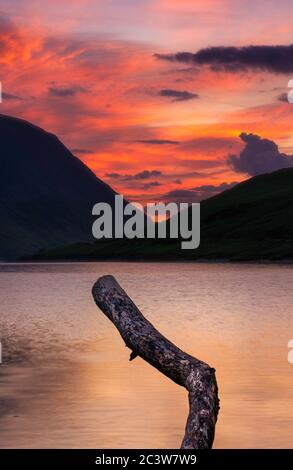 Spectacular sunset over Crummock water in Lake District, Cumbria,UK.Tranquil evening landscape scene with sky on fire over mountain lake. Stock Photo