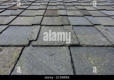 Old roof slate tiles roof with blue sky and clouds. Stock Photo