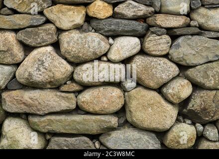 Rock wall of natural rounded river stones Stock Photo
