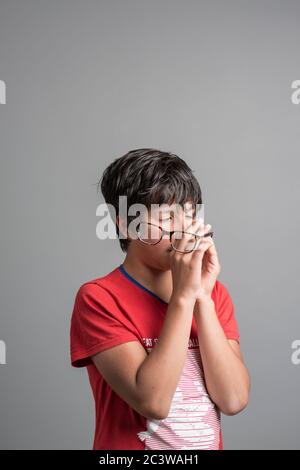 Young boy with cross yeyed vision holds correction glasses Stock Photo